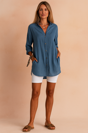 Stylish woman wearing a button-up blouse with rolled sleeves paired with white shorts