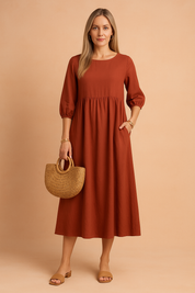 midi dress featuring three-quarter puff sleeves, a high gathered waistline, and a relaxed A-line silhouette