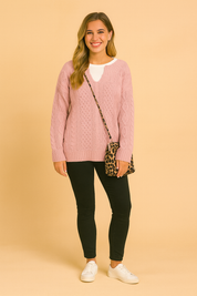Oversized sweater with classic cable pattern, paired with a white inner shirt, slim black pants, white sneakers, and a leopard-print shoulder bag