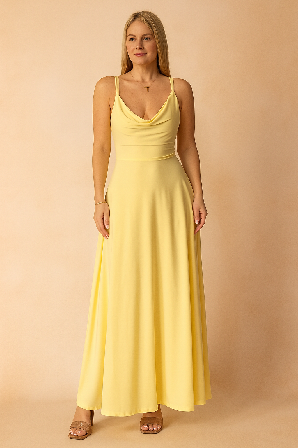 A yellow A-line maxi dress featuring a soft draped neckline and thin spaghetti straps, styled on a warm pastel background for a bright, elegant presentation.