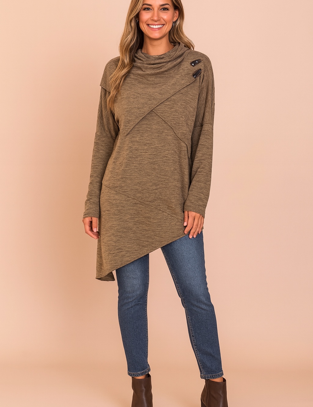 Asymmetrical heathered brown sweater with high cowl neckline, diagonal seam detailing, and three black button accents at the shoulder, paired with slim-fit blue denim jeans and dark brown ankle boots.
