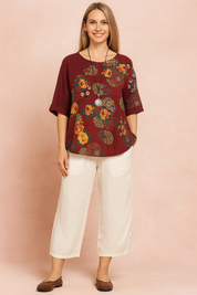 Boho-style asymmetrical burgundy blouse with floral and mandala patterns, featuring side buttons and loose-fit half sleeves.