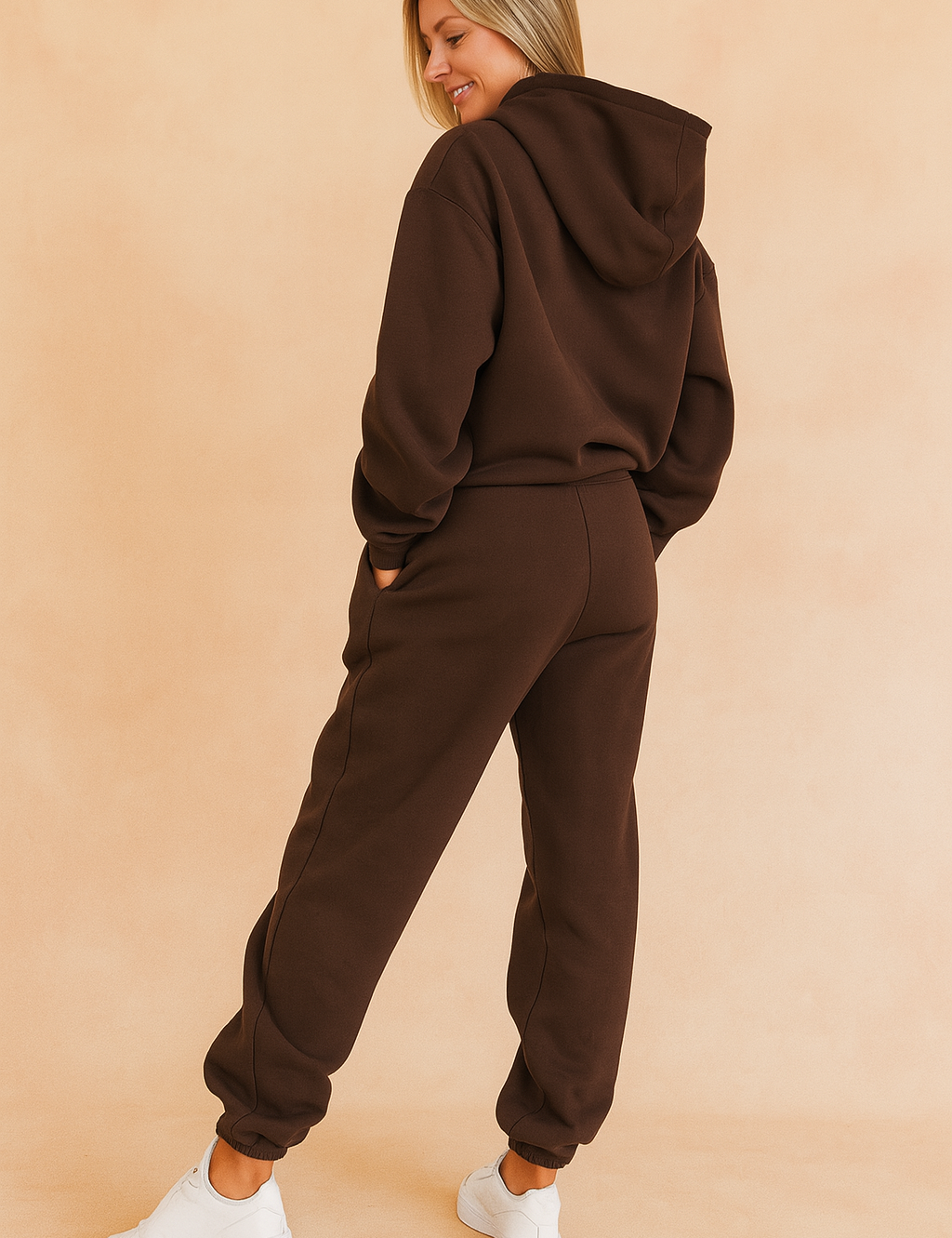 Back view of a dark brown hoodie and jogger co-ord set with elasticated cuffs and relaxed seams, styled for a clean and sporty silhouette paired with white sneakers.