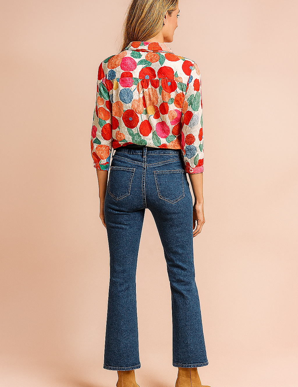 Colorful floral-print button-down blouse paired with high-rise straight-leg blue jeans and tan suede ankle boots, styled for a casual yet polished fashion-forward look.