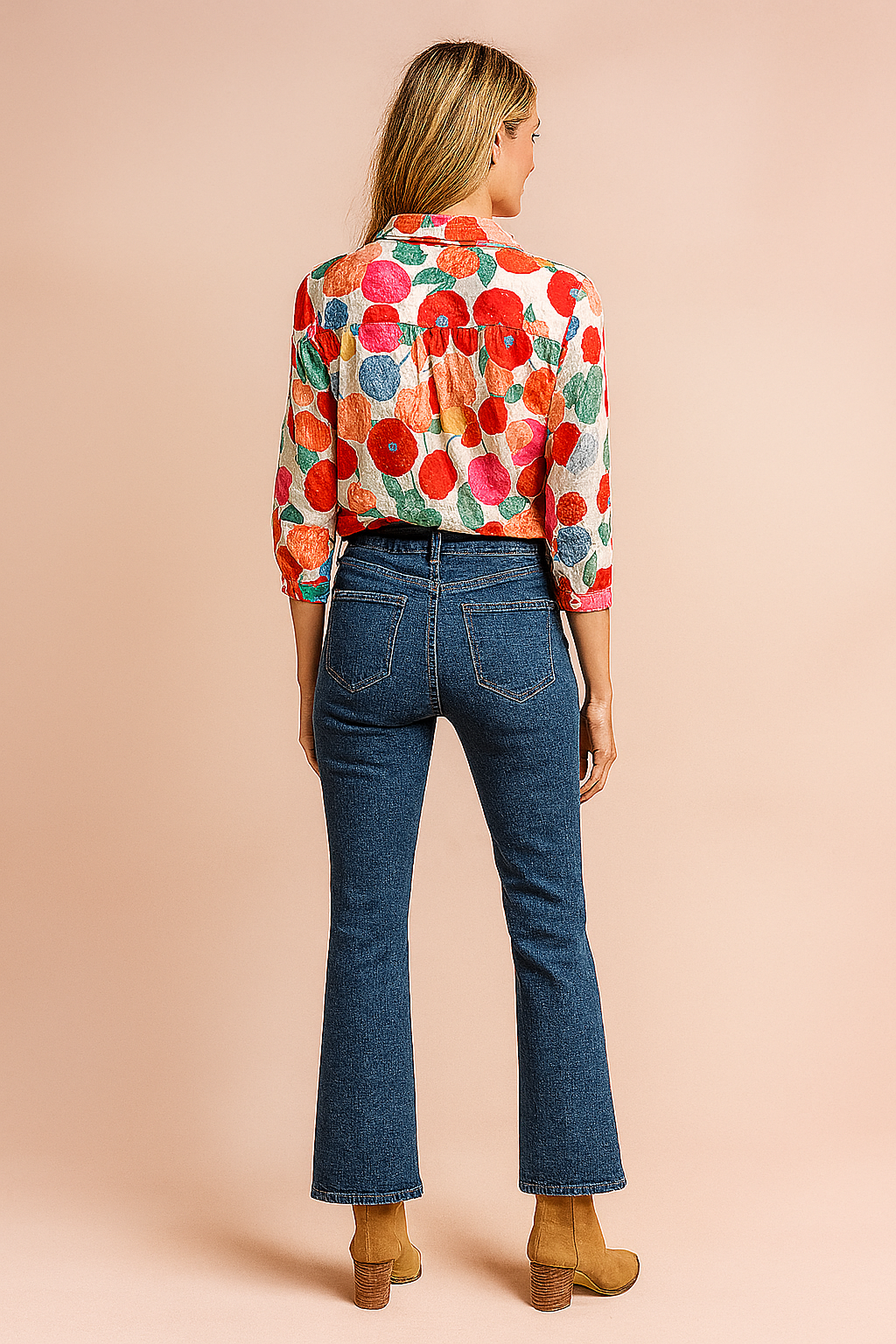 Colorful floral-print button-down blouse paired with high-rise straight-leg blue jeans and tan suede ankle boots, styled for a casual yet polished fashion-forward look.