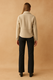 Beige button-down jacket with structured back seam, long sleeves, and double-buttoned cuffs, styled for a modern winter look.