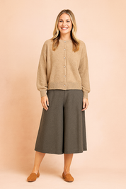 Heathered beige button-up cardigan with ribbed cuffs and hem, paired with wide-leg charcoal culottes and tan slip-on flats.