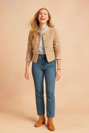 Beige textured button-down sweater jacket with long sleeves, gold buttons, and front pockets, styled with light blue blouse, denim jeans, and tan ankle boots