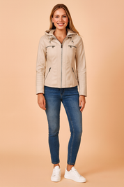Beige hooded zip-up jacket with multiple front zip pockets, paired with slim blue jeans and white sneakers, styled for a casual modern look.