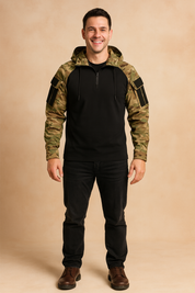 Tactical pullover hoodie with camouflage sleeves and hood, black torso, half-zip closure, and sleeve patch panels, styled in a rugged casual fit.