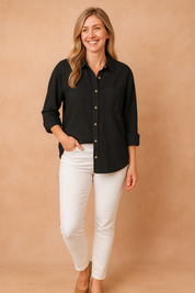 Casual black textured button-up blouse with front pocket and rolled sleeves, tucked slightly into white slim-fit jeans.