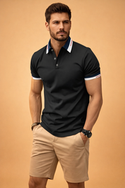 Black short-sleeve polo shirt with contrast navy and white collar, subtle red stripe detailing, three-button placket, fitted cut, paired with beige tailored knee-length shorts in smooth woven fabric
