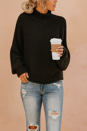 Black chunky knit turtleneck sweater paired with light blue distressed jeans, styled casually with a takeaway coffee cup.
