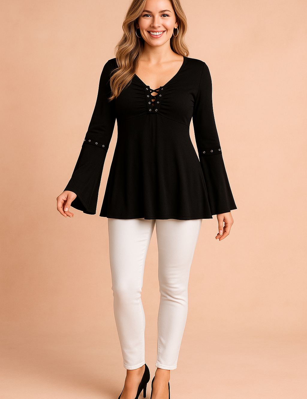 Black long-sleeve blouse with lace-up V-neckline, grommet details on the chest and sleeves, and flared cuffs, paired with fitted blue jeans.