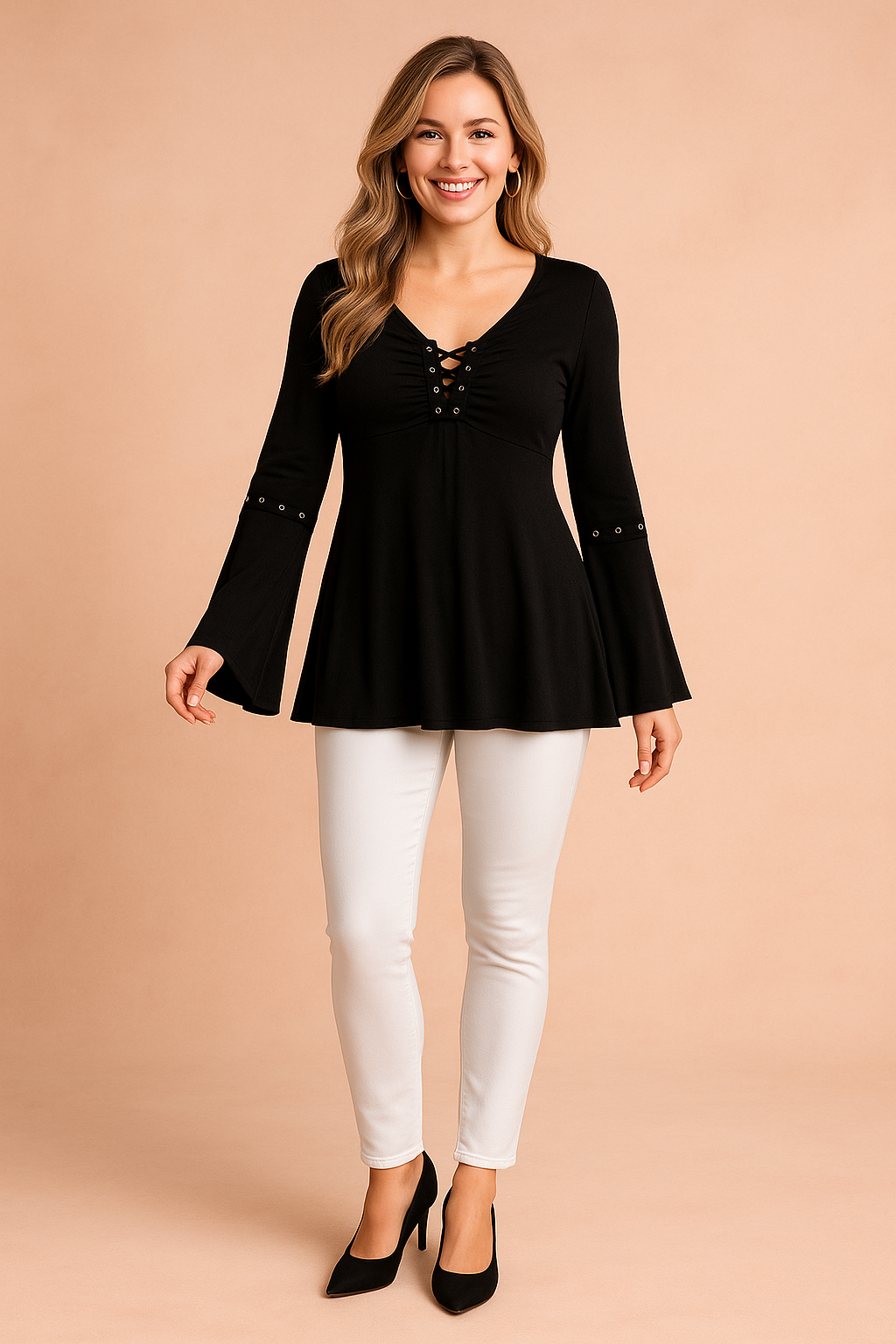 Black long-sleeve blouse with lace-up V-neckline, grommet details on the chest and sleeves, and flared cuffs, paired with fitted blue jeans.