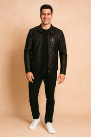 Black leather biker jacket with multiple zip pockets, quilted shoulder panels, and a sleek fitted cut, styled with black trousers and white sneakers.
