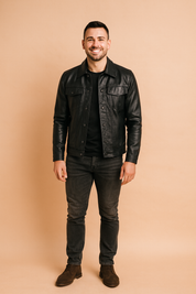 Black leather jacket with button closure, flap chest pockets, and tailored fit, styled in a modern casual look.