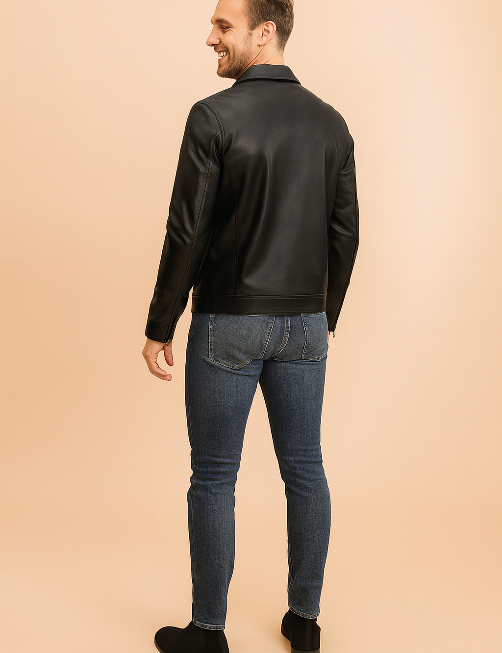 Black leather jacket with structured stitching and smooth matte finish, styled with slim blue jeans and black suede ankle boots, shown from the back view.