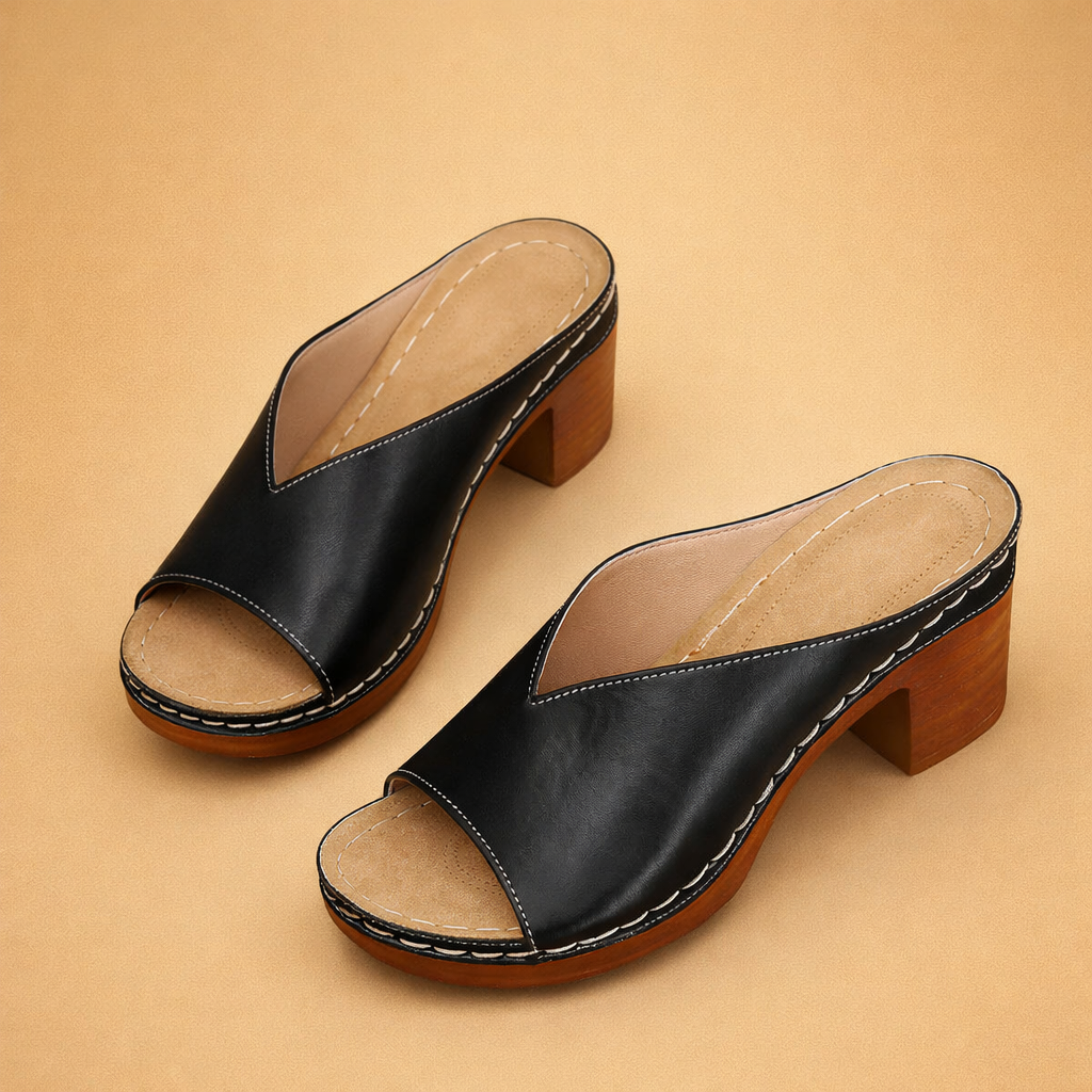 black-leather-mule-heels-model-studio-pose-caramel-sand-background.png