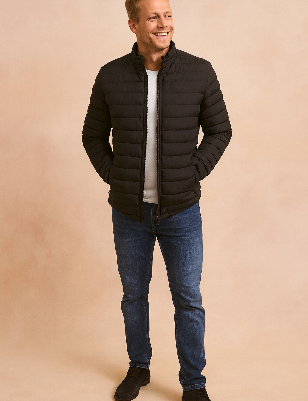 Black quilted puffer jacket with front zipper closure, horizontal stitched padding, and elastic cuffs, styled with a white crewneck T-shirt, blue slim-fit jeans, and black suede shoes.