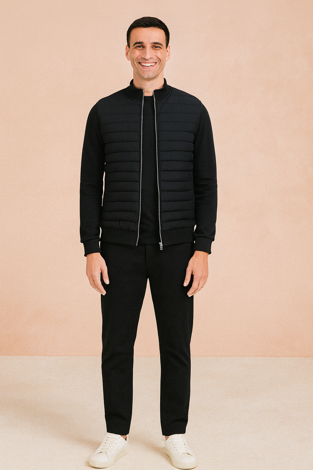 Black quilted zip-up jacket with ribbed cuffs and hem, styled with black trousers and white sneakers.