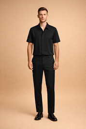 Black short-sleeve button-up shirt paired with matching tailored trousers and sleek black leather dress shoes, featuring a smooth matte fabric finish, clean seam construction, straight-leg cut, and a minimalist modern silhouette with precise drape and uniform deep-black color tone.