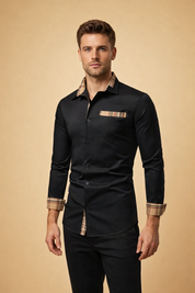 Slim-fit black long-sleeve button-up shirt with structured collar, clean front button closure, chest pocket detail, and contrasting plaid trim on inner collar, cuffs, and hem, styled with tailored black trousers.
