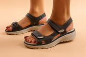 Black open-toe platform sandals with dual Velcro straps, contrast stitching, and a beige textured sole designed for everyday comfort and support.