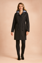 Black waterproof parka with drawstring waist, front snap buttons, large flap pockets, and a light blue hood lining, paired with fitted black pants and ankle boots.