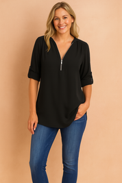 Black long-sleeve zip-front blouse with tab roll-up sleeves, styled with slim-fit blue jeans for a sleek, versatile casual outfit.
