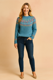 Blue Fair Isle knit sweater with multicolor teardrop motifs, paired with dark wash skinny jeans and beige pointed-toe heels.