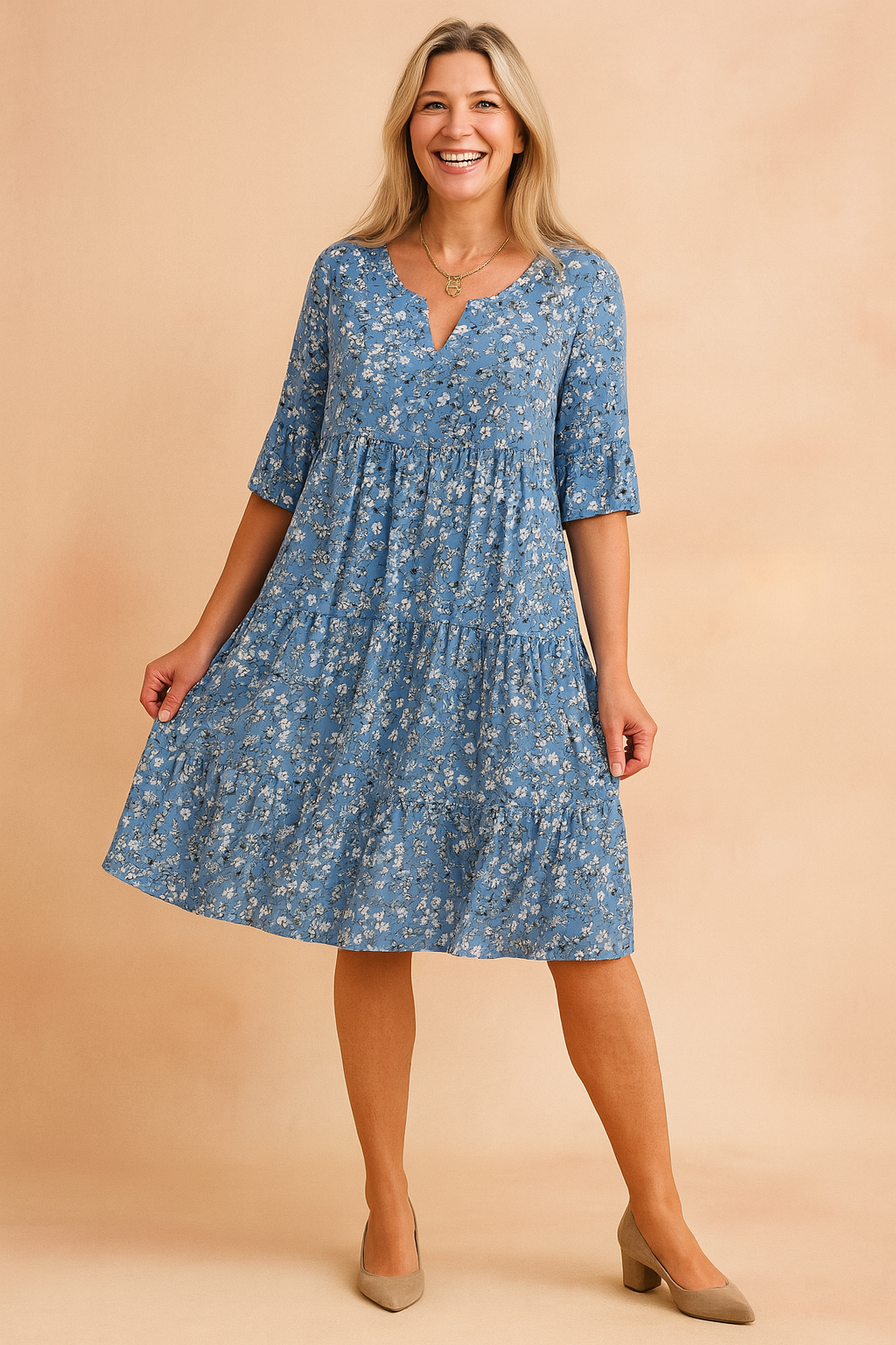 Flowy blue floral V-neck dress with half sleeves and tiered skirt, featuring an all-over daisy print in white and muted blue-gray tones, designed for a relaxed, breezy silhouette with precise seam detailing.