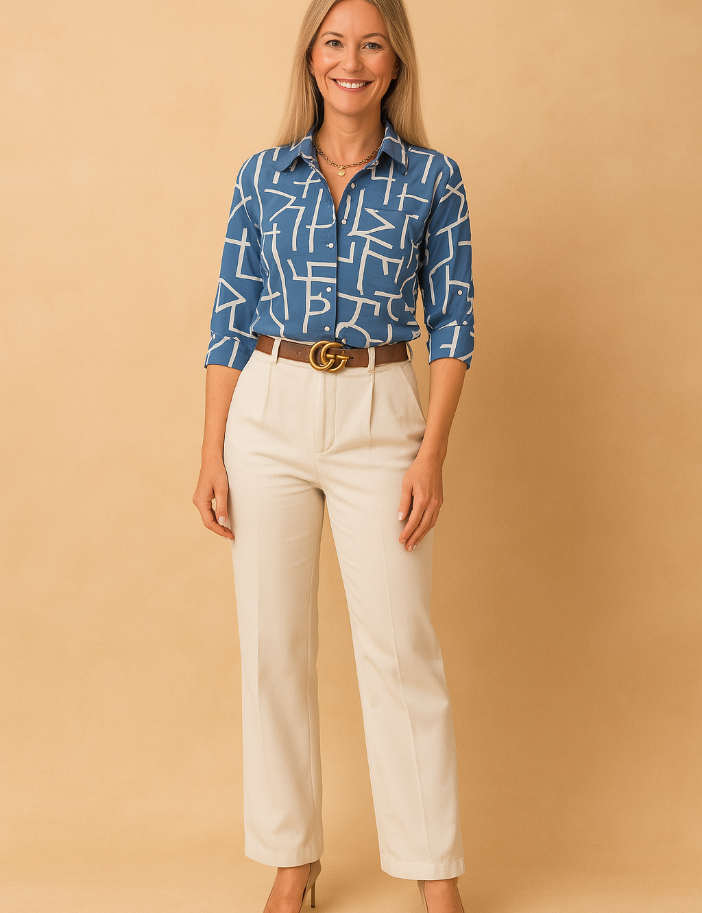 Blue button-up shirt with bold white abstract print, tucked into tailored ivory pants, accessorized with a brown belt and gold buckle.