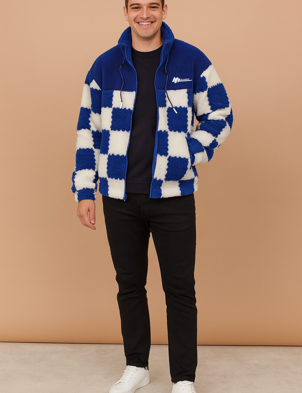 Blue and white checkerboard sherpa fleece zip-up jacket with drawstring collar, styled with black trousers and white sneakers.
