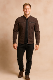Dark brown biker-style jacket with quilted shoulder and sleeve detailing, front zipper closure, four zippered pockets, paired with slim black jeans and brown leather boots.