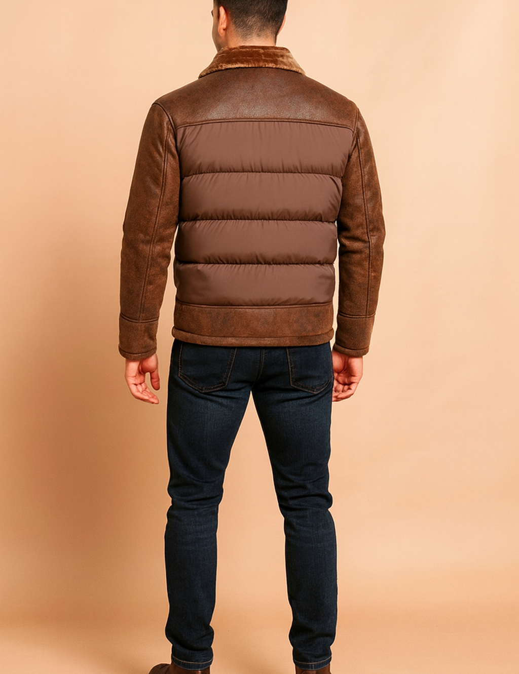 Brown bomber-style winter jacket with padded quilted panels, distressed leather sleeves and shoulders, and a soft faux fur collar, shown from the back to highlight the stitching and texture details.