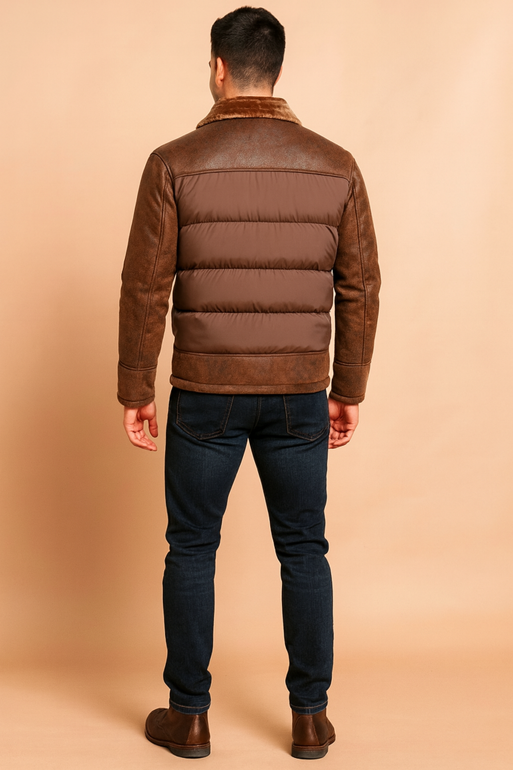 Brown bomber-style winter jacket with padded quilted panels, distressed leather sleeves and shoulders, and a soft faux fur collar, shown from the back to highlight the stitching and texture details.
