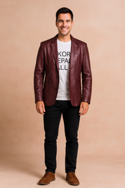 Men’s burgundy faux leather blazer with notch lapel, single-breasted button closure, and front flap pockets, tailored for a sleek and modern style.