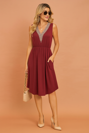 A sleeveless burgundy summer dress with embroidered neckline.