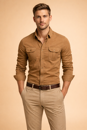 Camel brown long-sleeve button-up shirt with flap chest pockets and button cuffs, styled with beige straight-leg chinos and a dark brown leather belt.