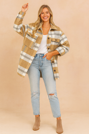 Oversized camel, white, and gray plaid jacket styled with a white T-shirt, distressed light-wash jeans, and taupe ankle boots.