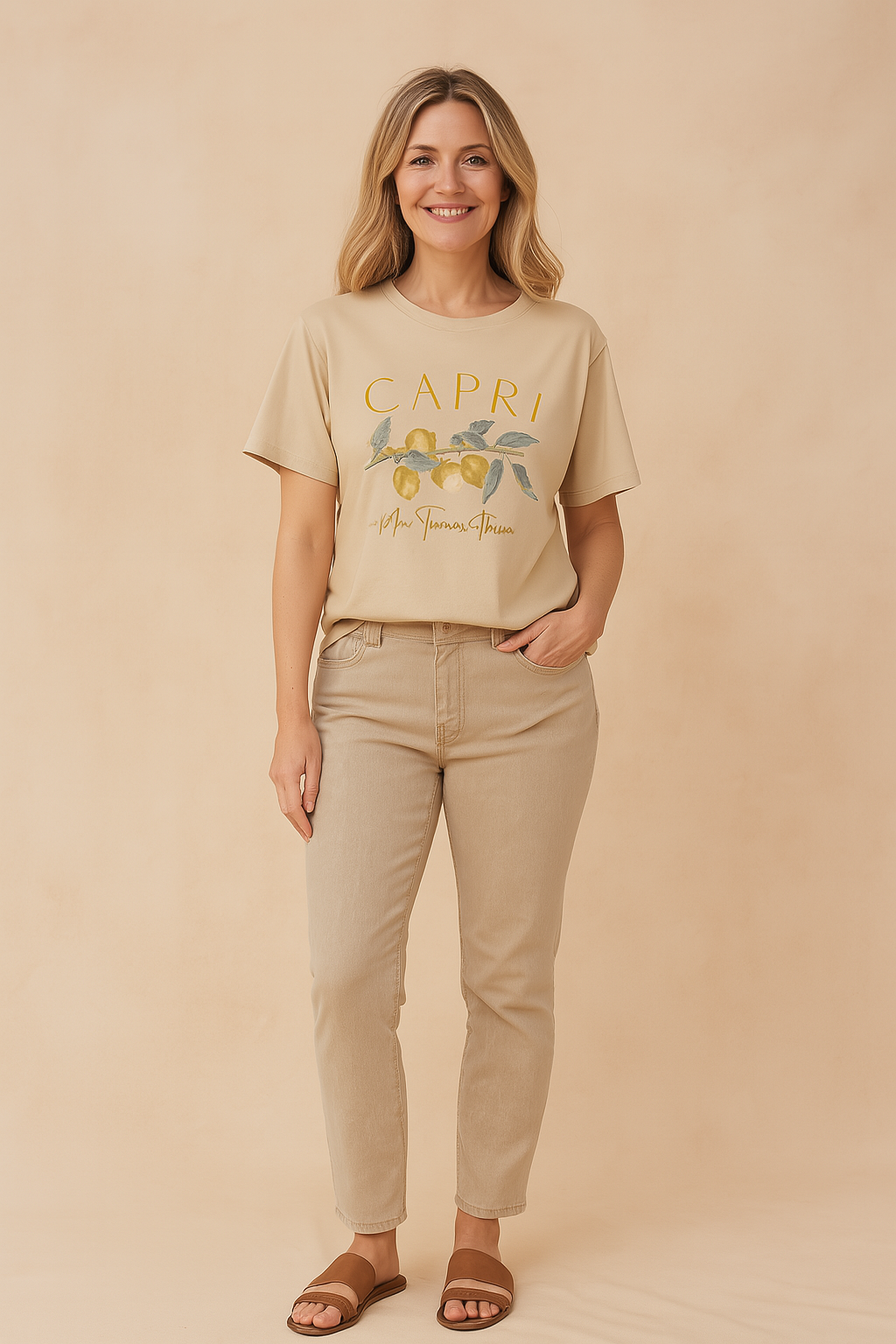 Oversized beige graphic T-shirt with a "Capri" lemon branch print and cursive script, styled with casual beige jeans and brown sandals.