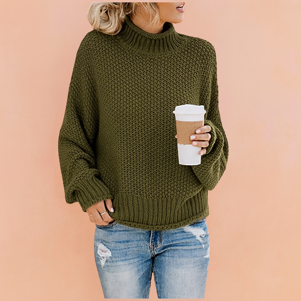 Olive green chunky knit turtleneck sweater with textured honeycomb pattern, paired with distressed light blue jeans.