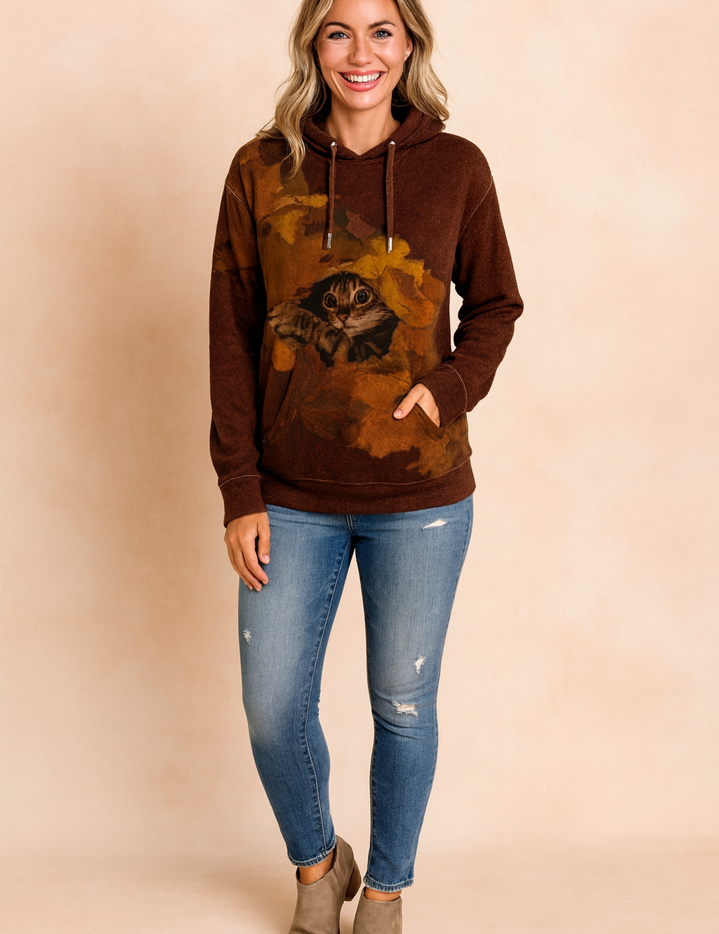 Chocolate brown hoodie with a detailed cat graphic in autumn leaves, paired with distressed blue skinny jeans and taupe suede ankle boots.