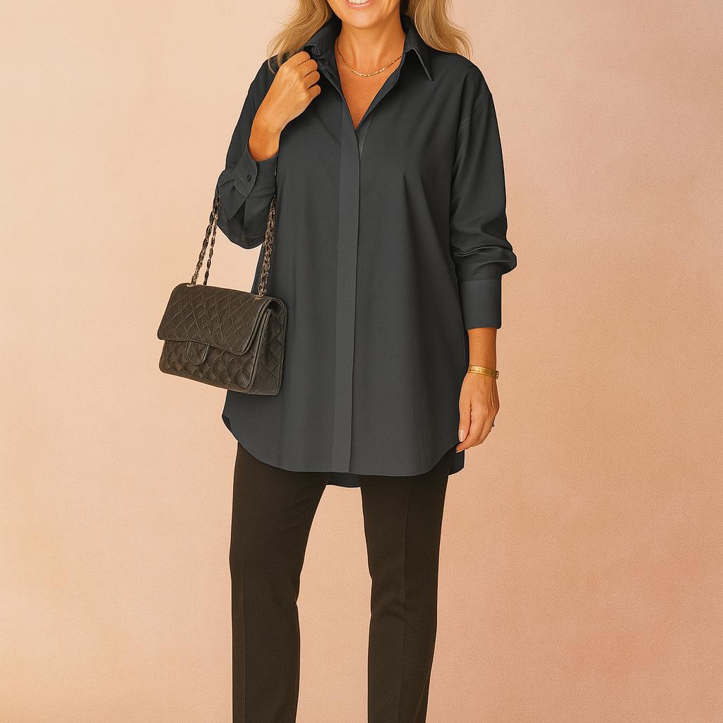 Oversized deep charcoal-gray button-up shirt with crisp collar and long sleeves, styled with slim black pants and a quilted black handbag featuring gold chain detailing.