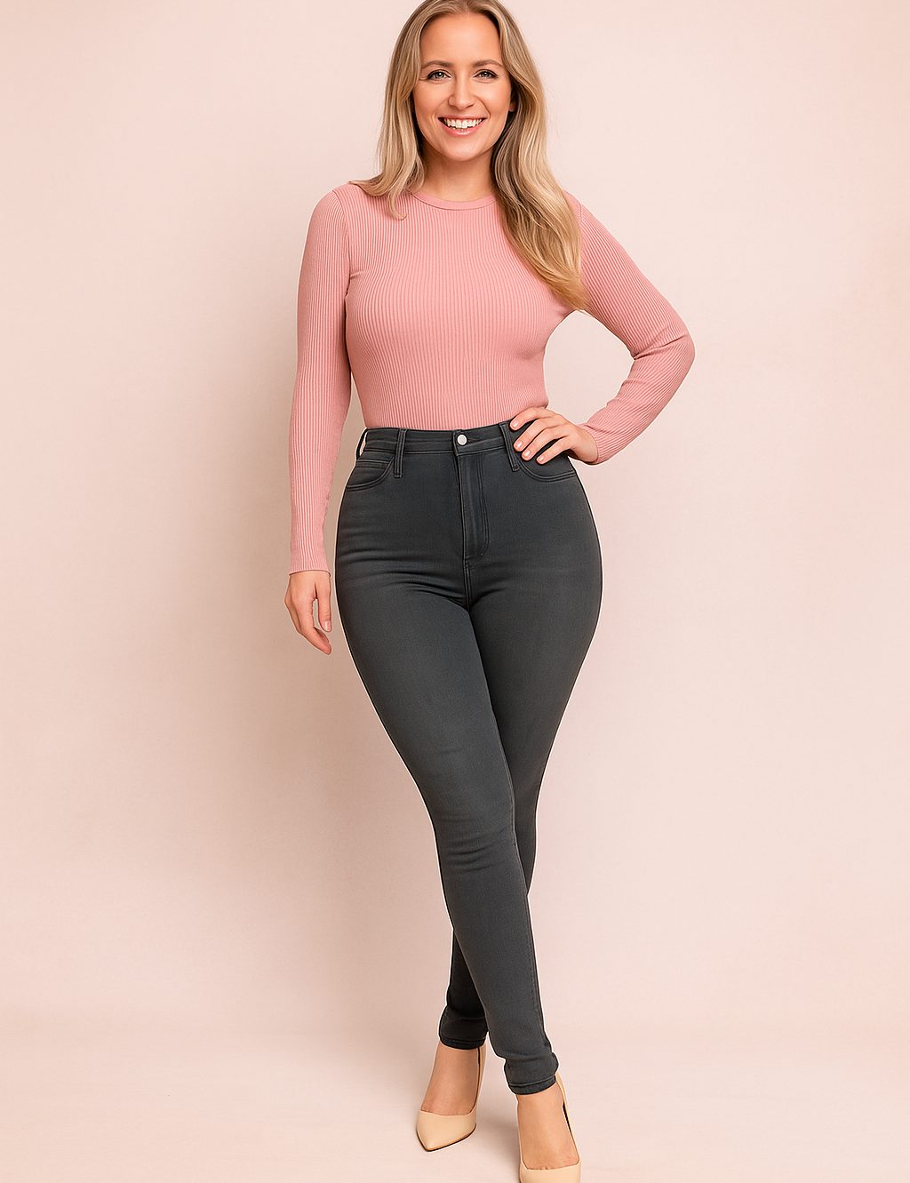 High-waisted charcoal gray skinny jeans paired with a fitted ribbed pastel pink long-sleeve top, styled with nude pointed-toe heels.
