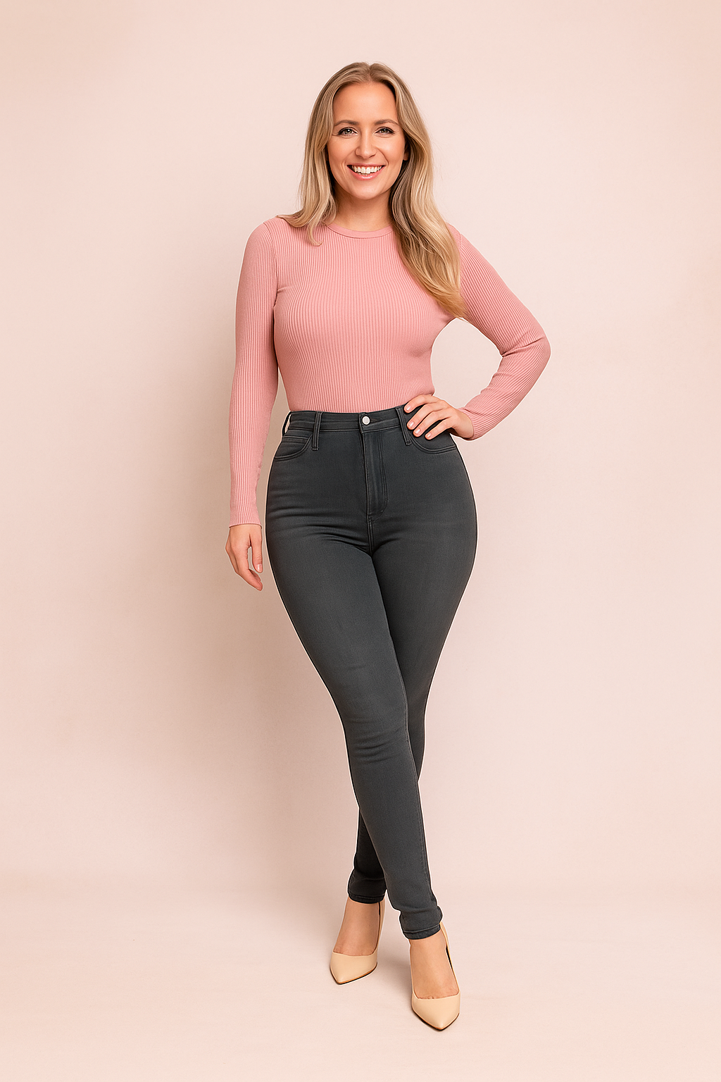 High-waisted charcoal gray skinny jeans paired with a fitted ribbed pastel pink long-sleeve top, styled with nude pointed-toe heels.
