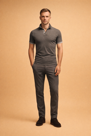 Charcoal grey short sleeve polo shirt with a fine heathered knit texture, contrast collar and button placket, tailored slim fit silhouette, paired with clean low-top sneakers for a refined modern casual look