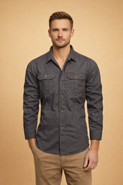 Charcoal grey long-sleeve utility shirt with structured button-front closure, dual flap chest pockets, tailored straight fit, reinforced seams, and clean cuffed sleeves paired with light khaki straight-leg trousers