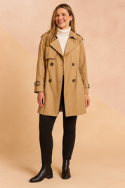 Classic camel trench coat with double-breasted button closure, waist cinch detailing, belted cuffs, and paired with a white ribbed turtleneck, black slim-fit pants, and black leather ankle boots.